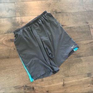 Gray and blue nike running shorts with pockets